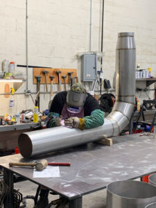 Welder TIG welding a metal fitting