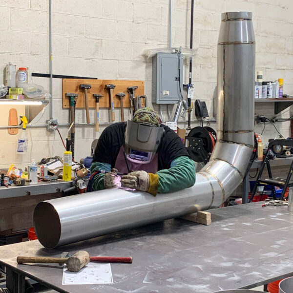 Welder TIG welding a metal fitting
